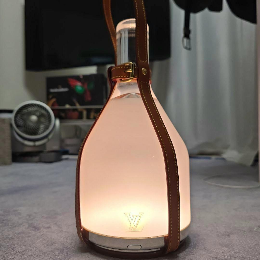 Louis Vuitton Bell Lamp LED floor lamp with leather carrying strap illuminated and LV logo visible.