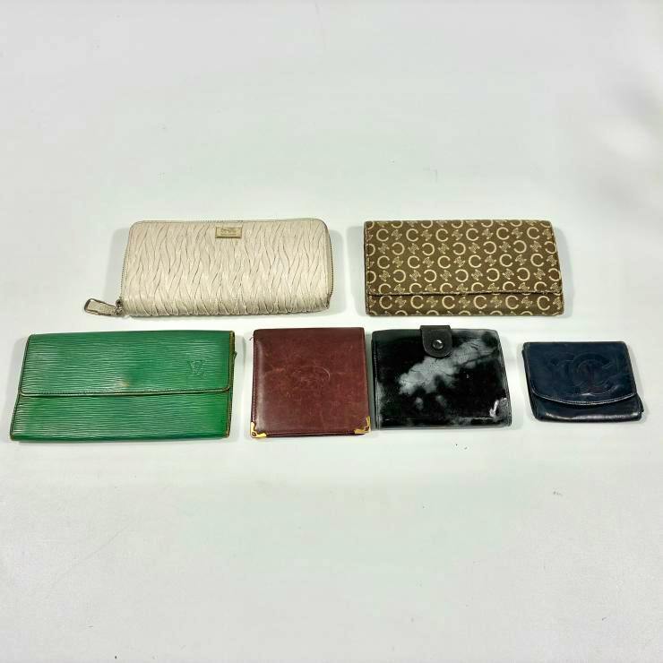 Six wallets of various styles and colors arranged on a white background.