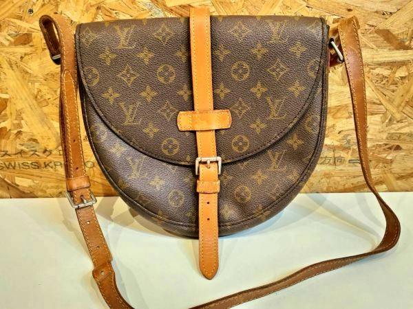 Front view of the brown Louis Vuitton monogram canvas shoulder bag with leather strap and front buckle.