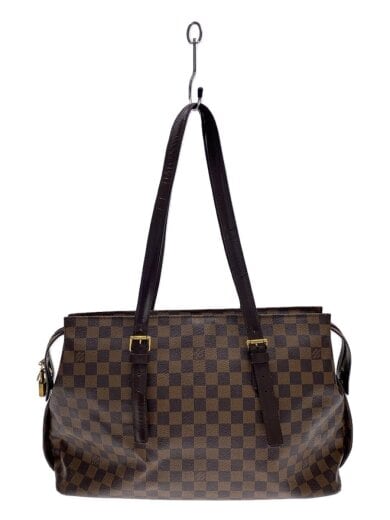 Front view of a brown checkered shoulder bag with two long dark brown straps hanging from a hook.