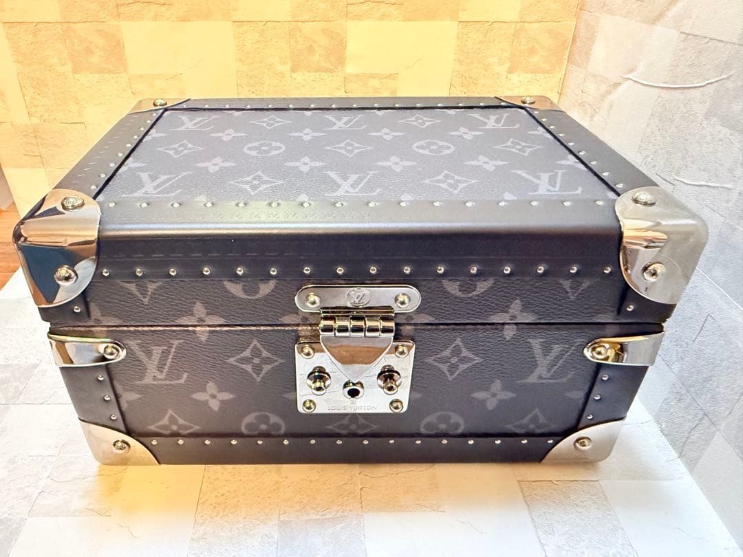 LOUIS VUITTON Coffret Trésor 24 Monogram Eclipse trunk with dark monogram canvas, metal corner protectors, and a front latch.