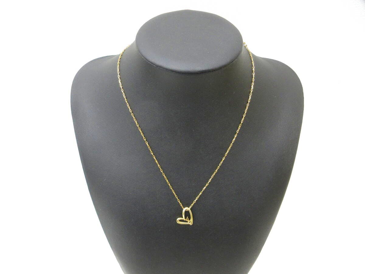 Gold Louis Vuitton heart pendant necklace displayed on a black mannequin bust.