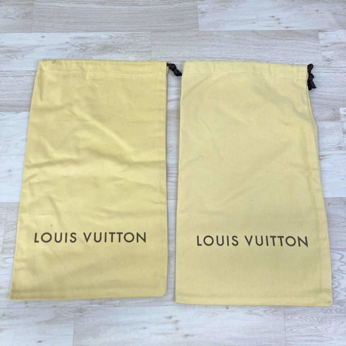 Two cream-yellow Louis Vuitton cotton drawstring storage bags laid flat showing the printed LOUIS VUITTON logo.