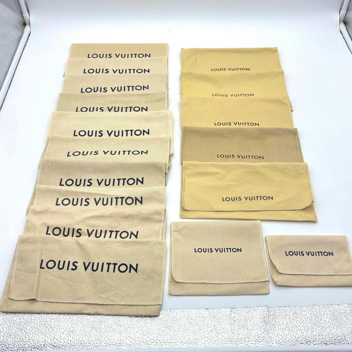 Multiple Louis Vuitton cotton pouches/dust bags in beige tones arranged in rows on a white background.