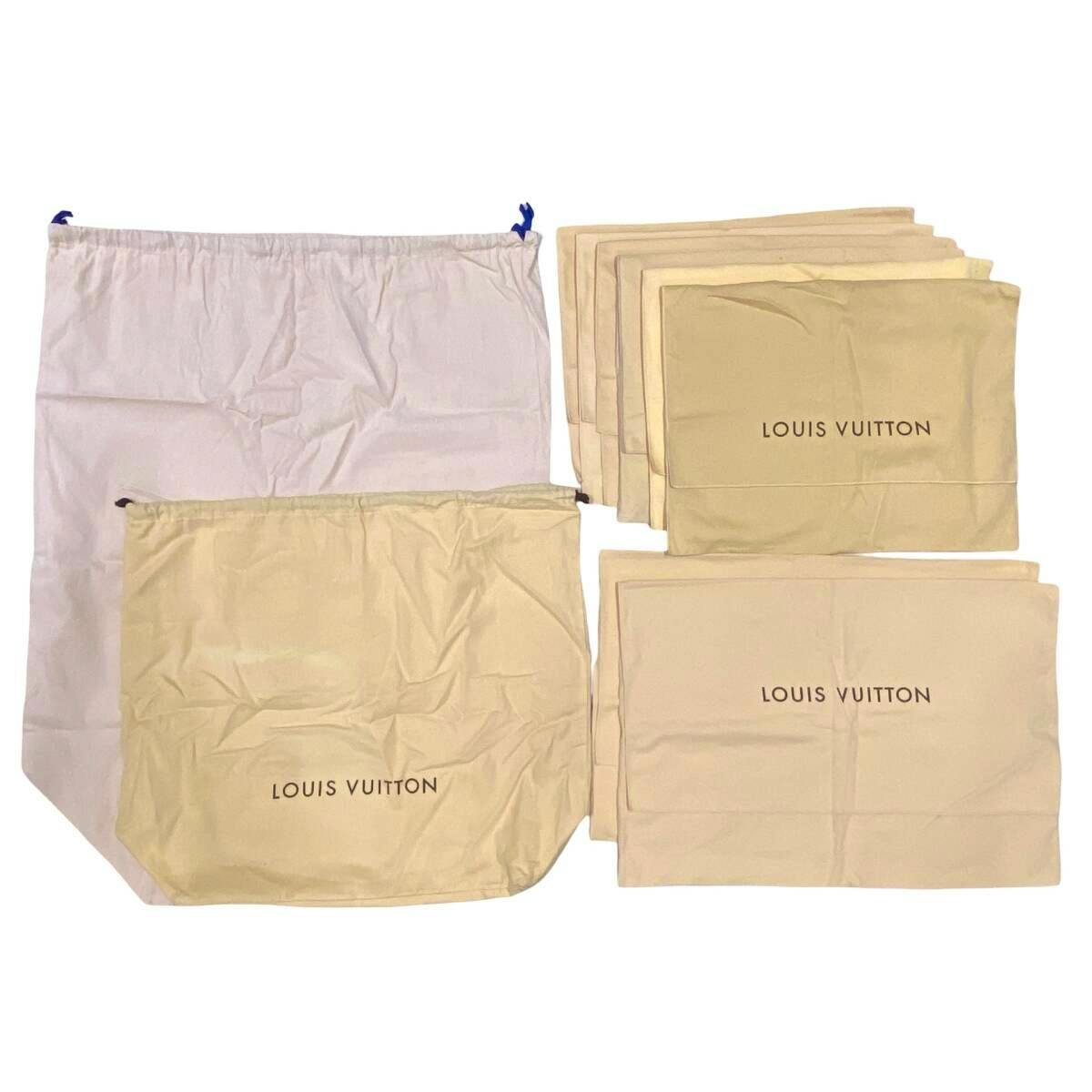 Multiple beige Louis Vuitton dust bags and a larger light-colored storage bag laid flat, showing the printed "LOUIS VUITTON" text.