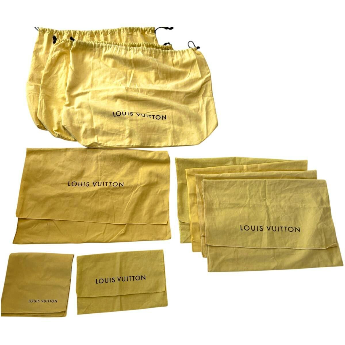 Multiple yellow Louis Vuitton cotton dust bags and pouches laid out on a white background.