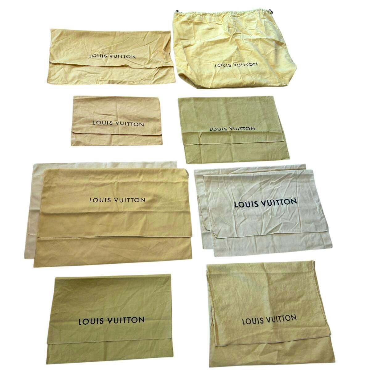 Multiple Louis Vuitton cotton dust bags in beige, white, and yellow laid flat, showing the LOUIS VUITTON logo.
