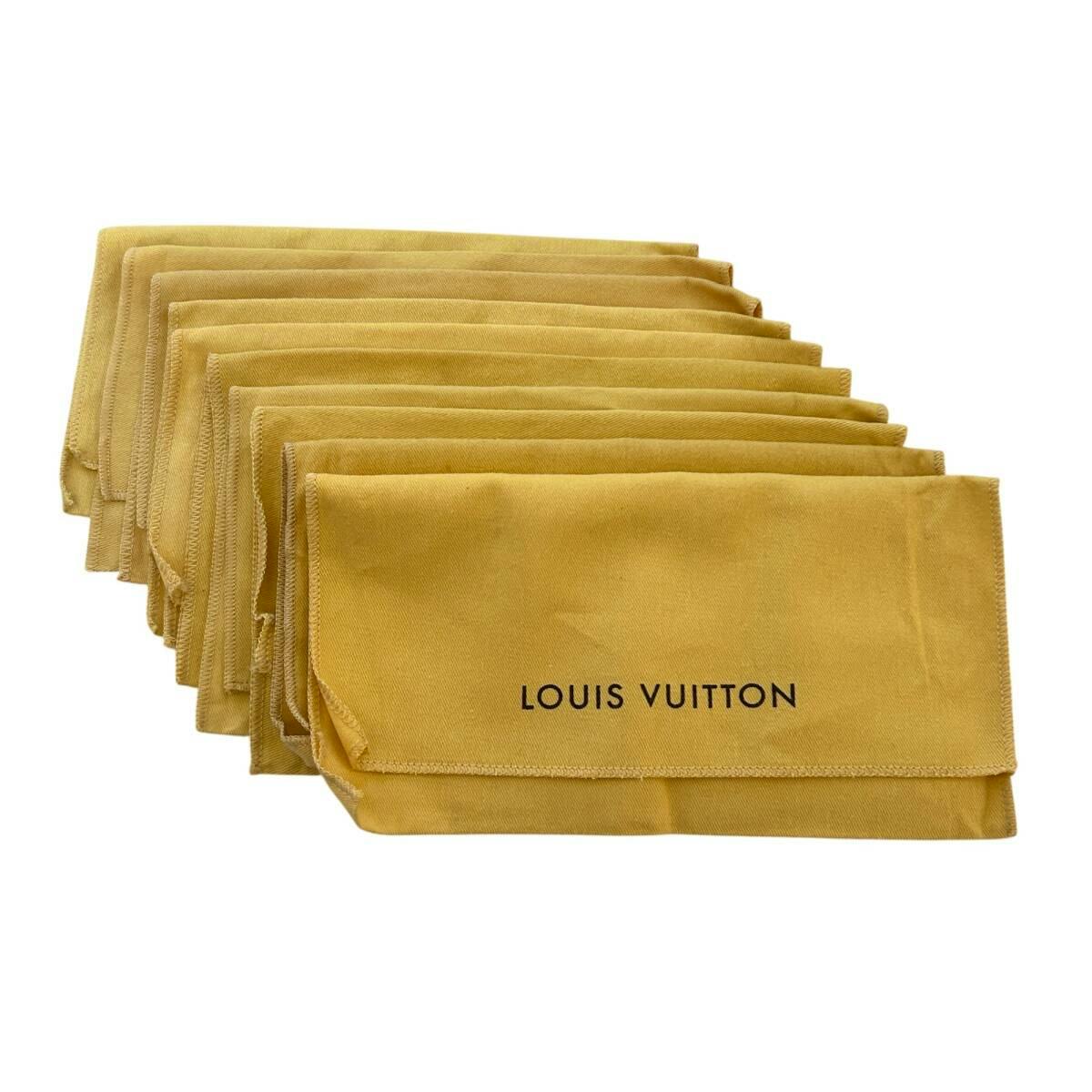 Stack of beige Louis Vuitton cotton dust bags with "LOUIS VUITTON" printed on the front.