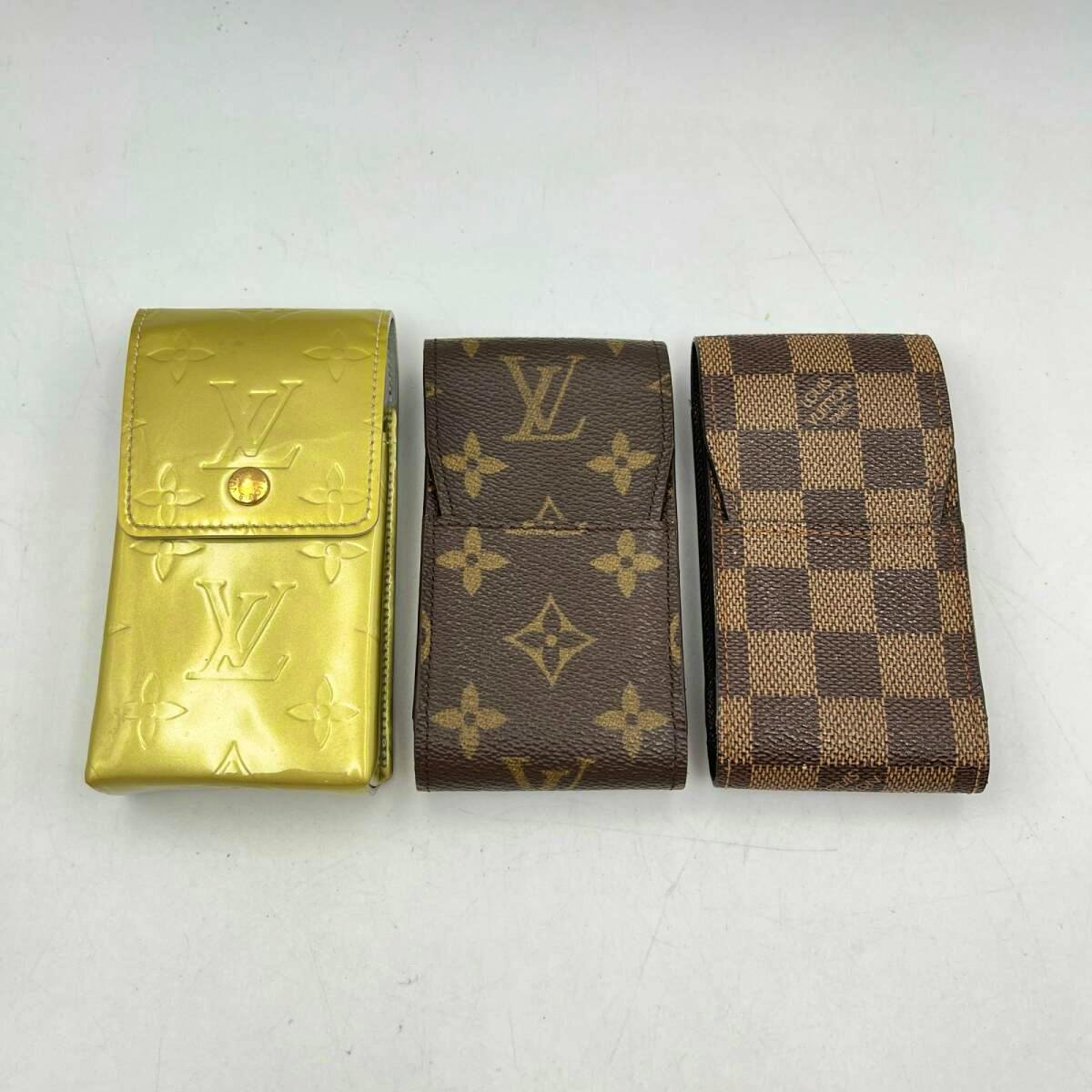 Three Louis Vuitton cigarette cases—one gold monogram, one brown monogram, and one Damier check—laid side by side on a white background.