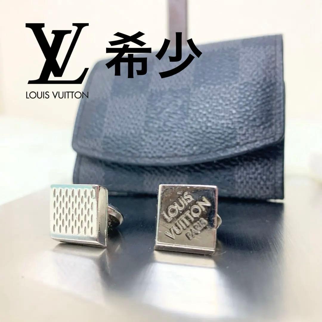 Pair of Louis Vuitton square cufflinks, one face showing "LOUIS VUITTON PARIS," displayed in front of a small textured pouch.