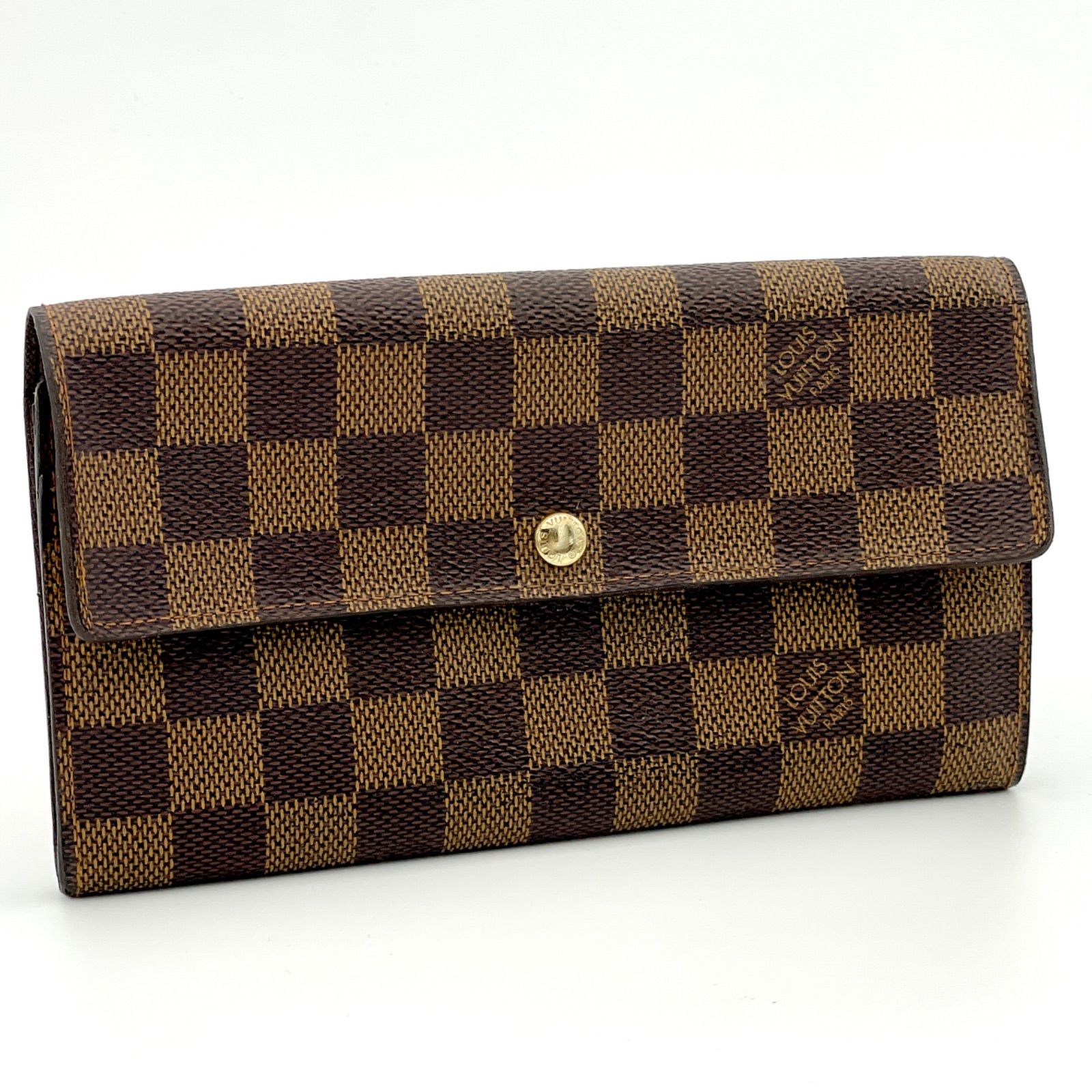 Brown Louis Vuitton Damier Ebene canvas flap wallet with a gold snap button visible from the front.