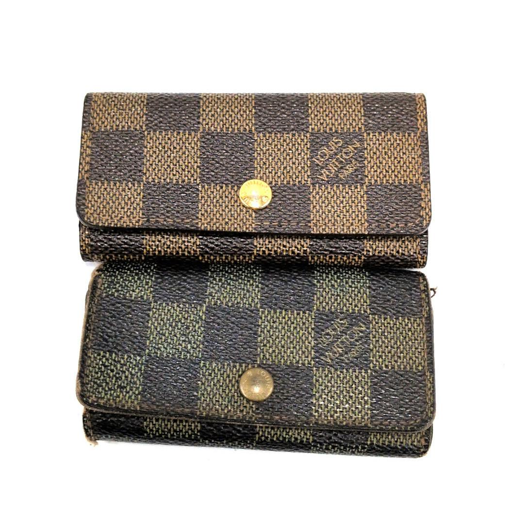 Two Louis Vuitton Damier canvas four-key key cases are stacked on a white background showing their front flaps and snap closures.