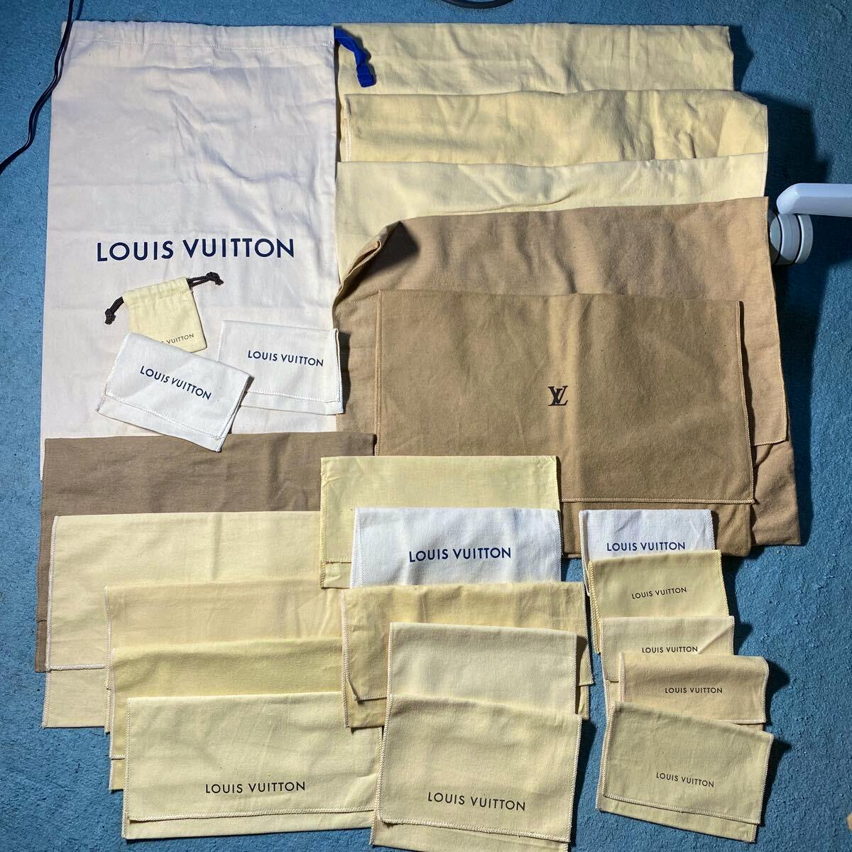 Multiple Louis Vuitton beige and brown cotton dust bags and pouches laid flat showing printed "LOUIS VUITTON" text and an LV logo.