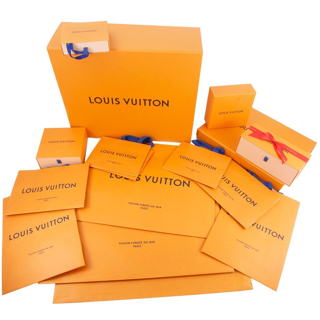 Multiple Louis Vuitton orange boxes, paper bags, and ribbons arranged on a white background.