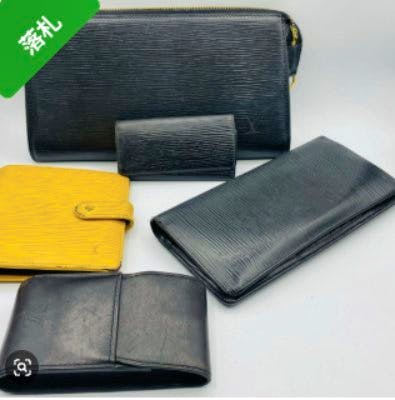 Five Louis Vuitton Epi-style items (wallets, key case, and similar small leather goods) in black and yellow arranged on a white background.