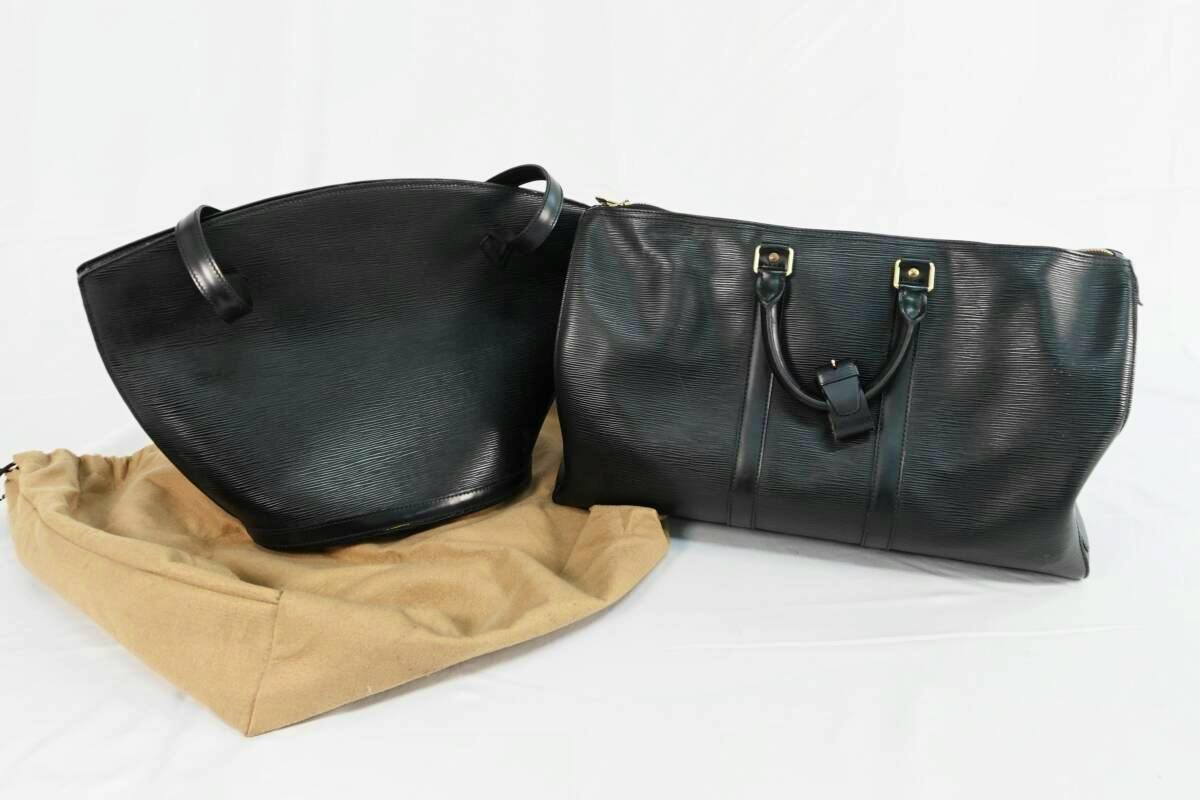 Two black Louis Vuitton Epi leather bags displayed side by side with a beige dust bag on a white background.