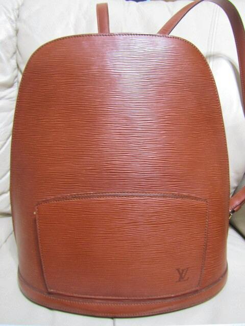 Front view of a Louis Vuitton Epi Kenya brown leather backpack showing textured leather, front pocket, and embossed LV logo.
