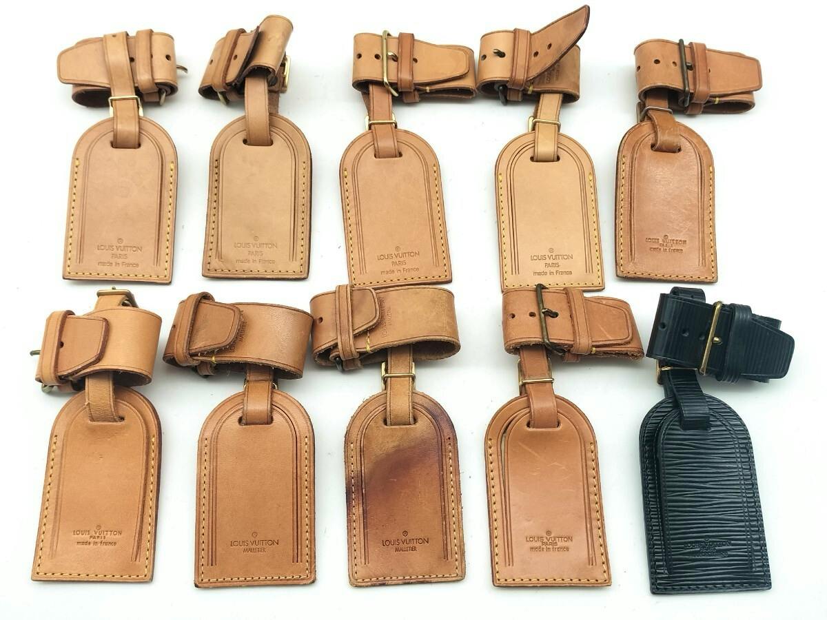 Ten Louis Vuitton leather luggage name tags arranged on a white background, mostly natural vachetta leather with one black tag.