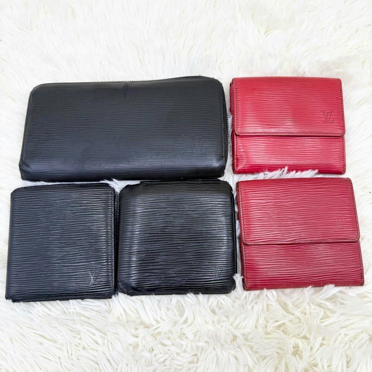 Five Louis Vuitton Epi leather wallets (three black, two red) arranged on a white fur surface.