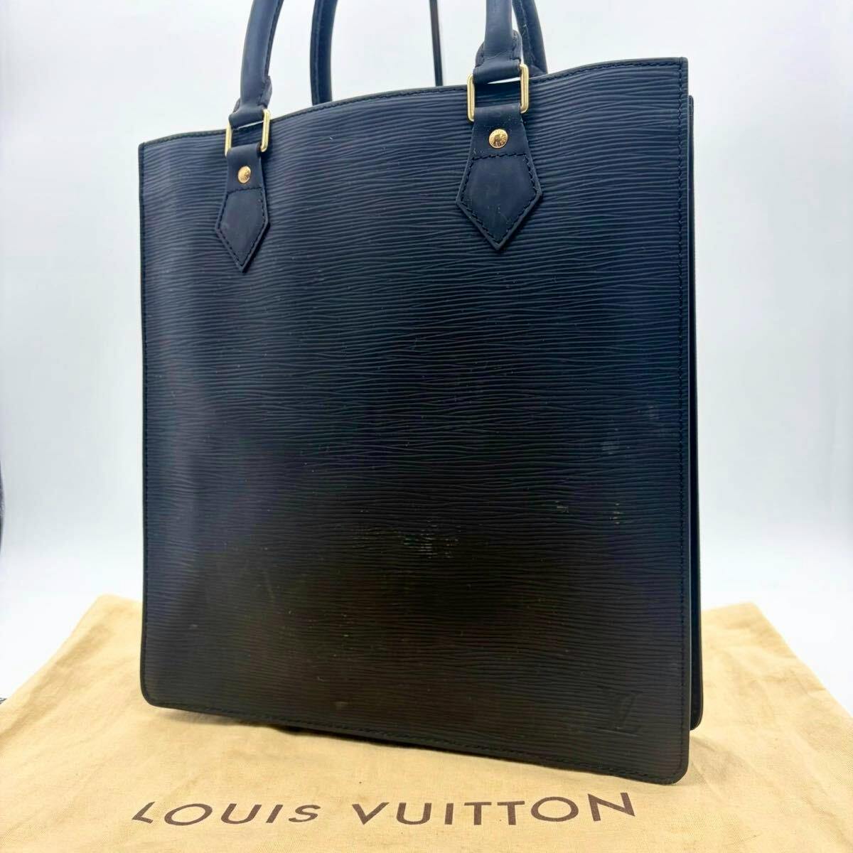 Front view of the black Louis Vuitton Epi tote/business handbag placed on a Louis Vuitton dust bag.