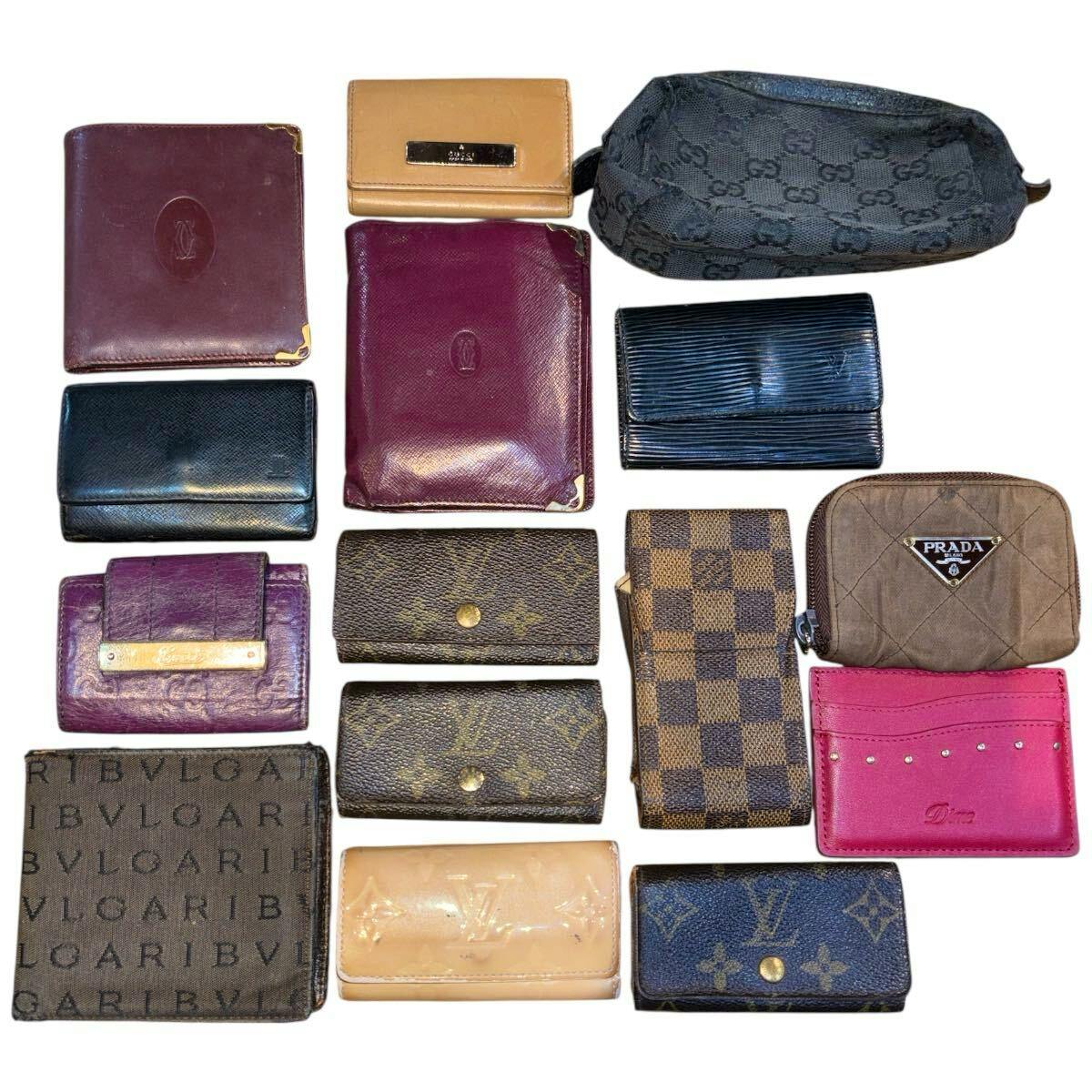 Assorted branded wallets and small leather accessories arranged on a white background.