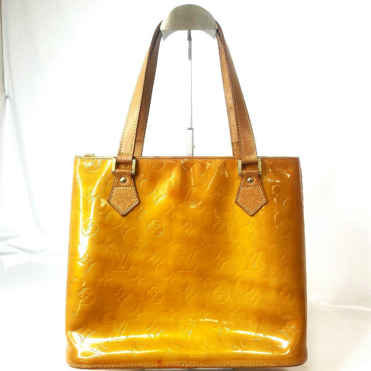 Front view of a yellow Louis Vuitton Houston tote bag with embossed monogram and leather shoulder straps on a white background.