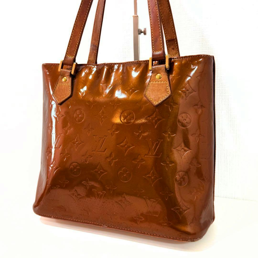 Front view of the LOUIS VUITTON Houston Vernis bag showing the embossed monogram and shoulder straps.