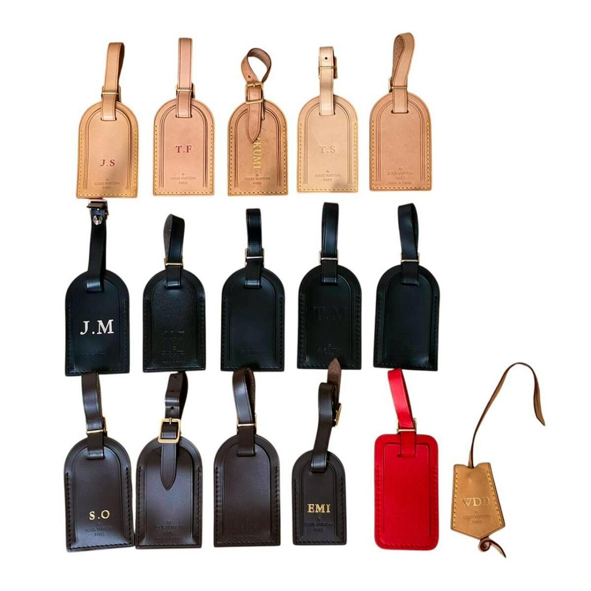 A set of Louis Vuitton leather name-tag luggage charms in several colors arranged on a white background.