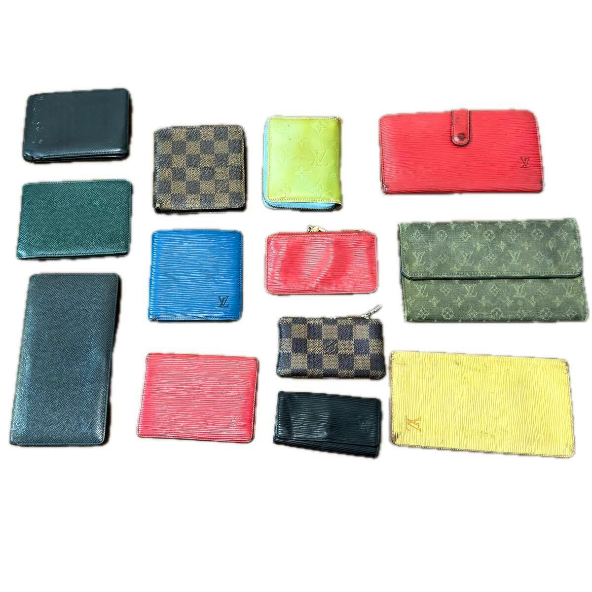 Multiple Louis Vuitton wallets and small leather cases in various colors and patterns laid out on a white background.