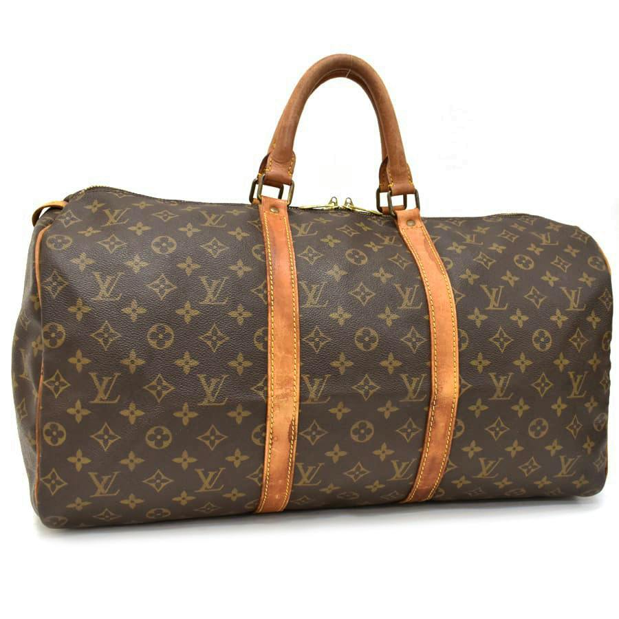 Louis Vuitton monogram canvas brown duffel-style bag with brown leather handles and straps visible against a white background.