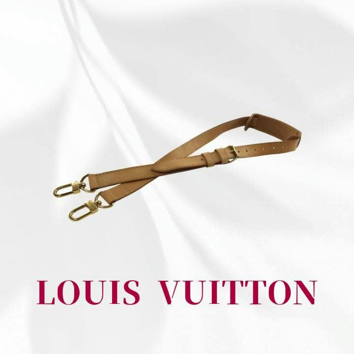 Tan natural leather adjustable shoulder strap with shoulder pad and gold-tone clips for a Louis Vuitton Keepall, shown on a white background with "LOUIS VUITTON" text.