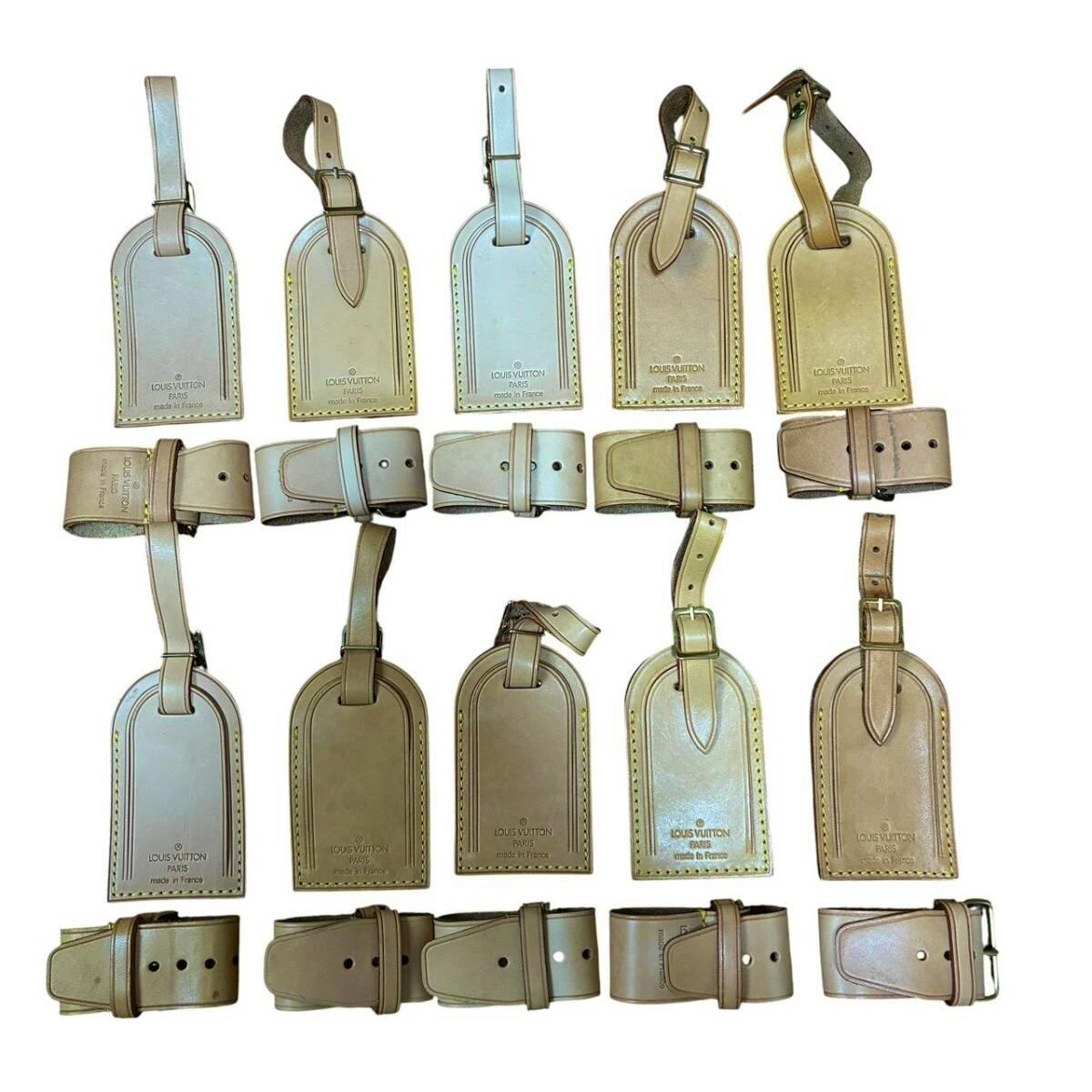 Ten Louis Vuitton leather name tags with their straps arranged on a white background.