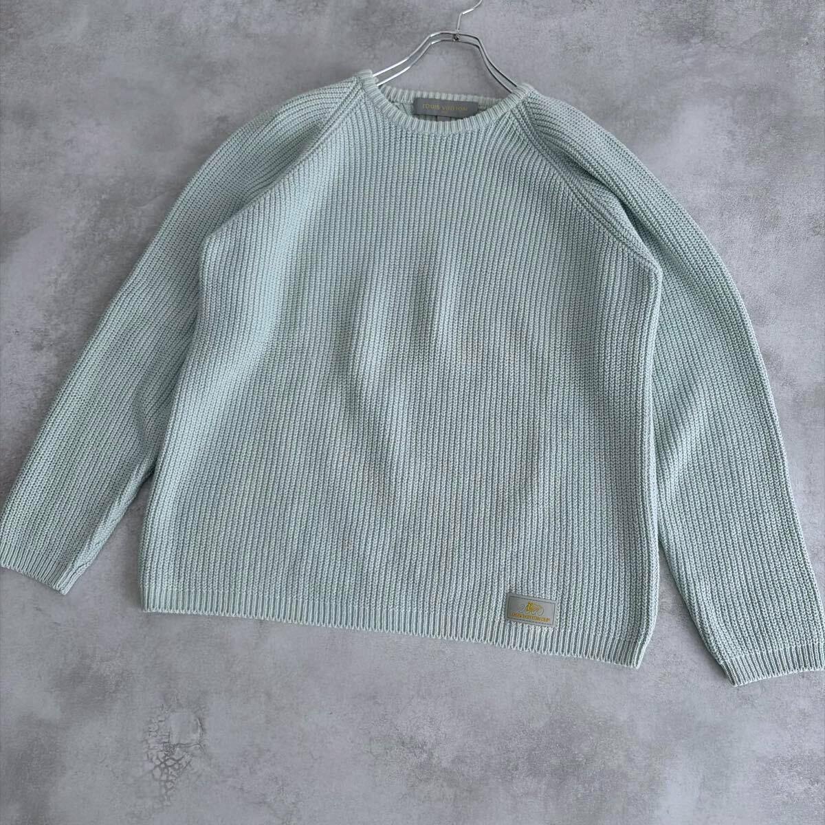 Light green Louis Vuitton cotton knit pullover sweater laid flat on a gray background showing front and sleeves.