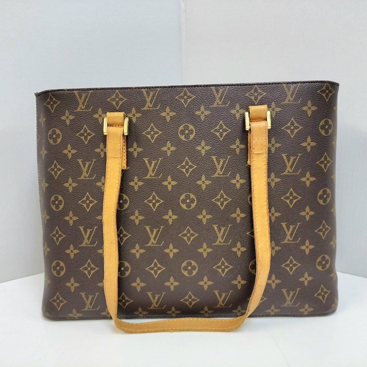 Front view of a Louis Vuitton monogram canvas tote bag with tan leather shoulder straps.