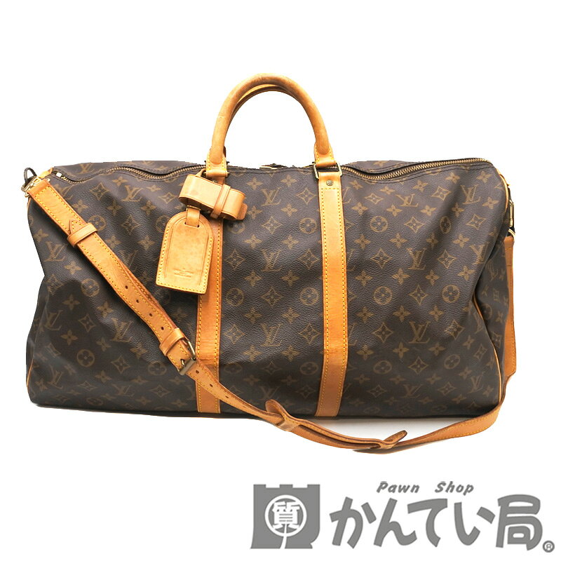 Front view of a Louis Vuitton M41414 monogram Keepall Bandoulière 55 duffle bag with cow-leather handles and a shoulder strap on a white background.