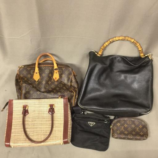 Five bags arranged on a gray background, including a Louis Vuitton monogram Speedy30 at top left, a black bag with a bamboo handle at top right, a woven tote lower left, a small black pouch center, and a Louis Vuitton monogram cosmetic pouch lower right.