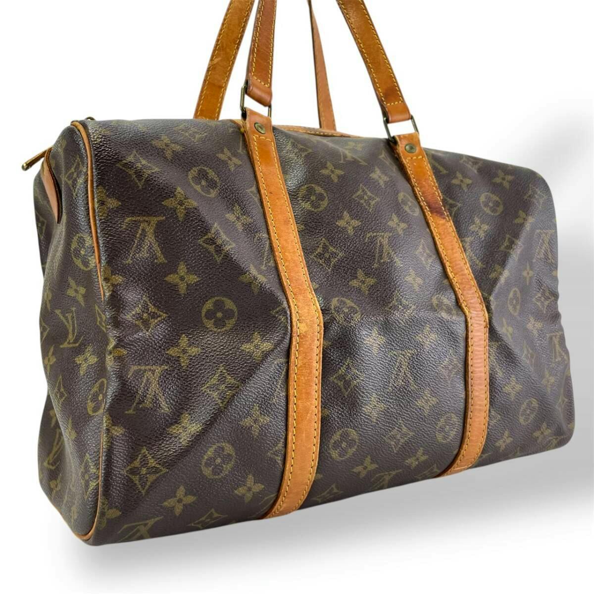 Front-side view of the Louis Vuitton Monogram Sac Souple 35 travel handbag showing the monogram canvas and leather handles.