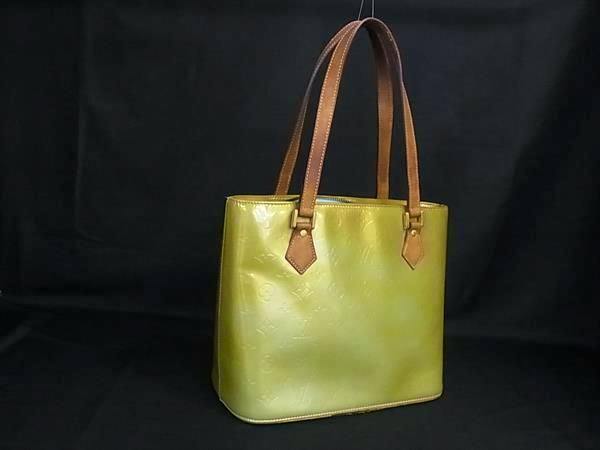 Green Louis Vuitton Monogram Vernis Houston tote handbag with brown leather shoulder straps on a black background.