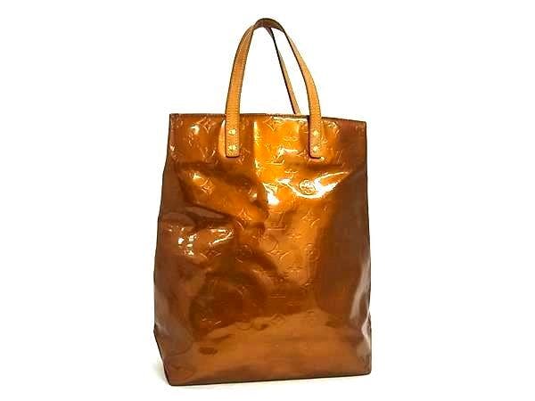 Bronze Louis Vuitton Monogram Vernis Lead MM tote handbag standing against a white background.