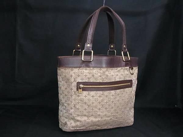 Front view of the LOUIS VUITTON Monogram Mini Lucille GM tote bag in beige canvas with brown leather trim and top handles against a black background.