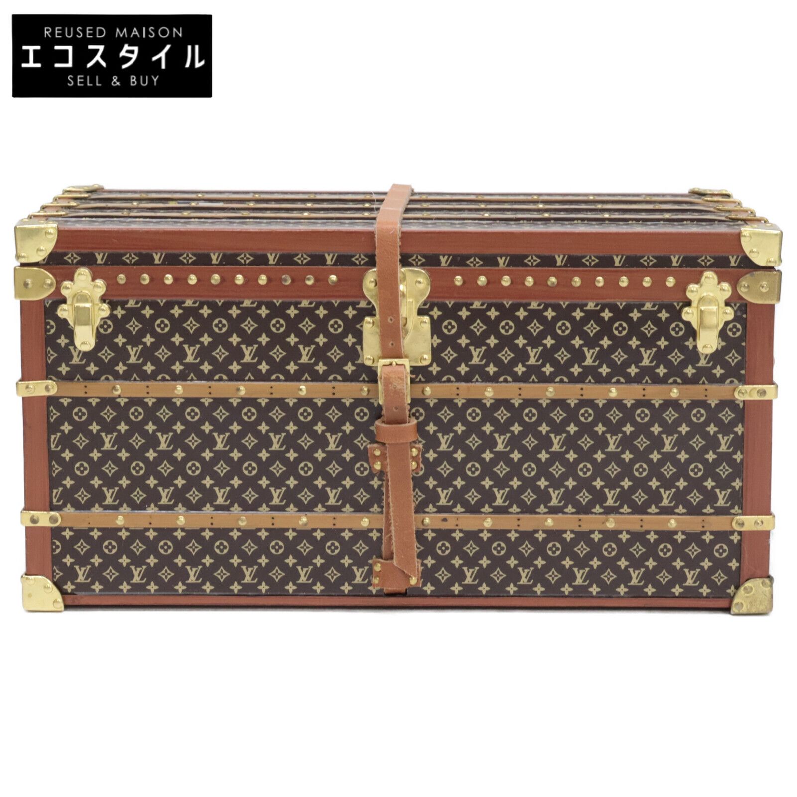 Front view of a Louis Vuitton trunk-shaped paperweight showing monogram print, leather strap, and metal corner fittings.