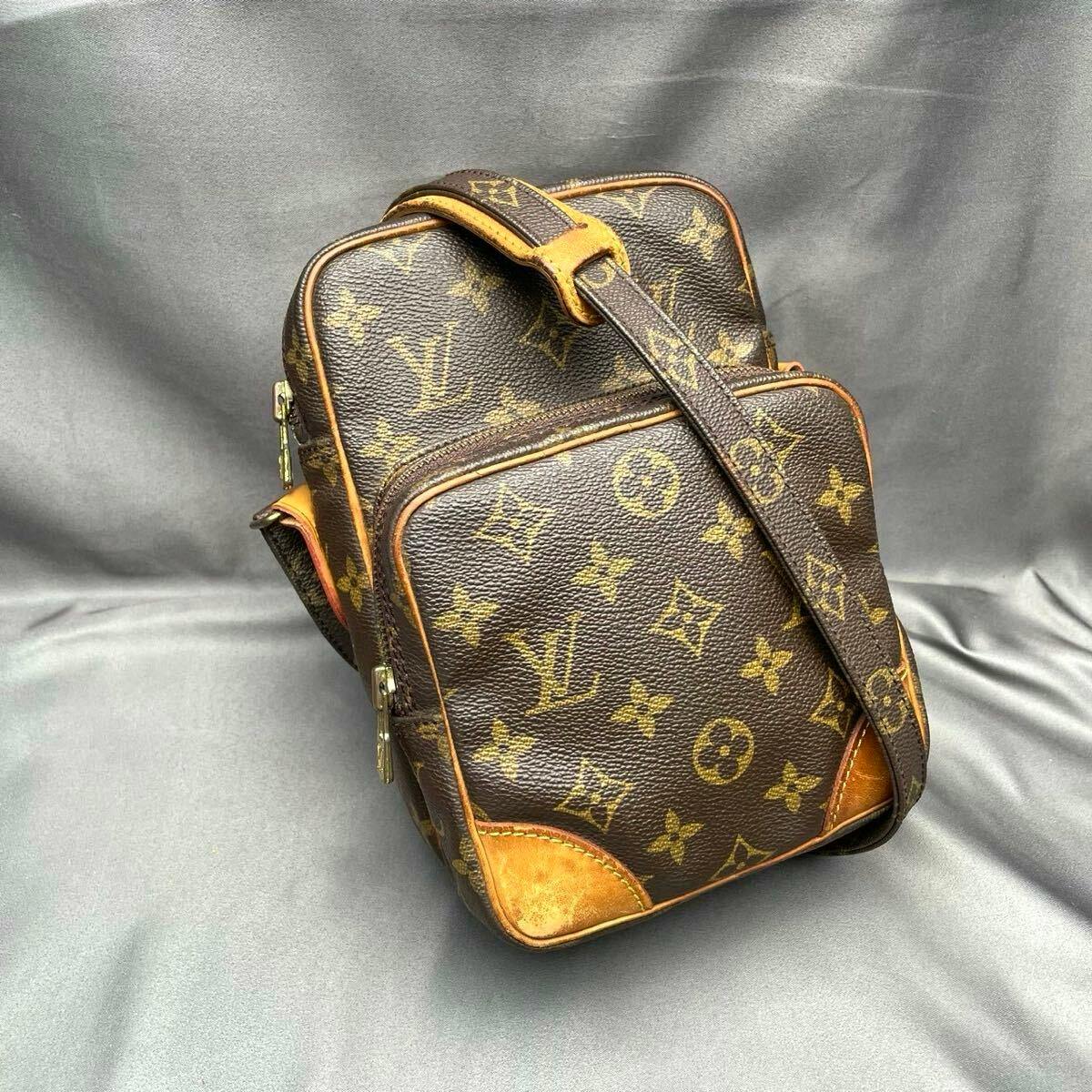 Louis Vuitton monogram shoulder (Amazon) bag with leather trim and adjustable strap photographed on a gray background.