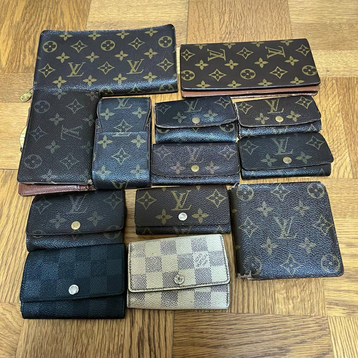 Top-down photo of a set of Louis Vuitton monogram and Damier wallets and small leather goods (13-piece set) arranged on a wooden floor.