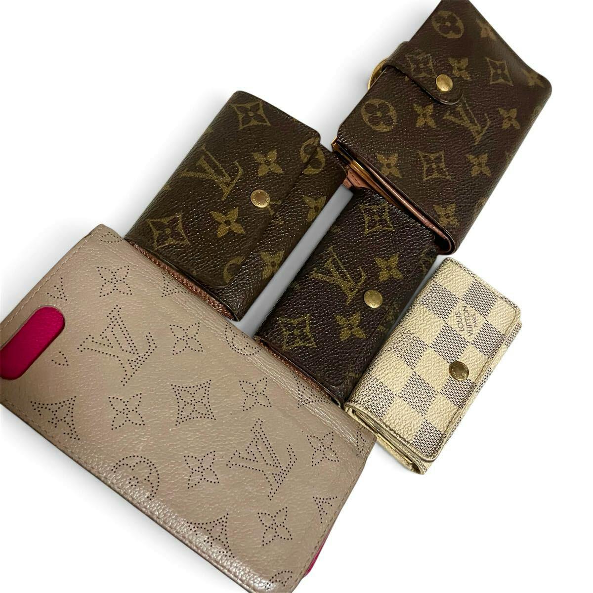 Several Louis Vuitton wallets and small leather goods in monogram and checkered patterns on a white background.