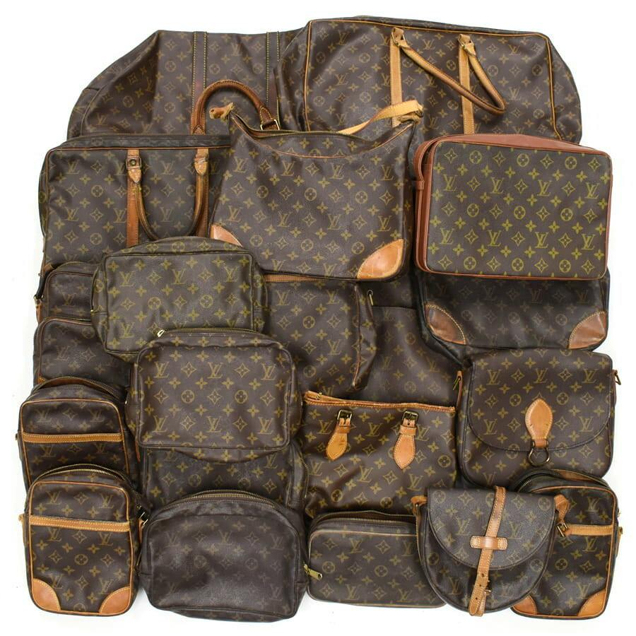 Multiple Louis Vuitton monogram canvas bags and luggage pieces arranged together in a bulk set.