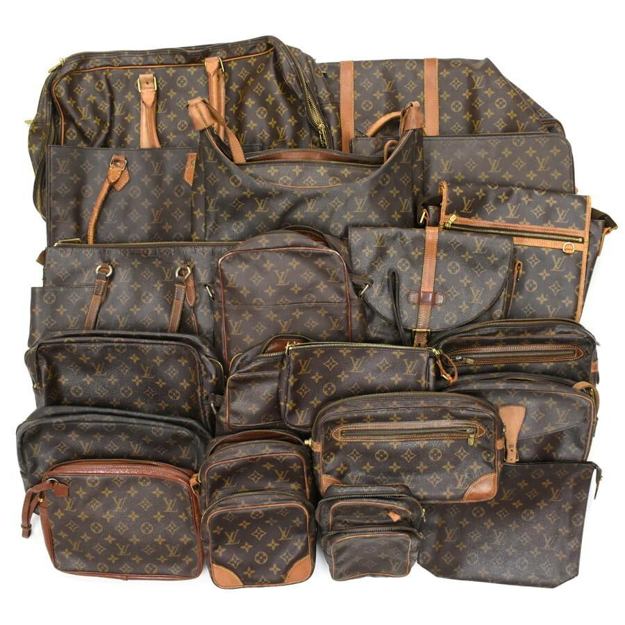 A group of Louis Vuitton monogram canvas bags, pouches, and clutches displayed together.