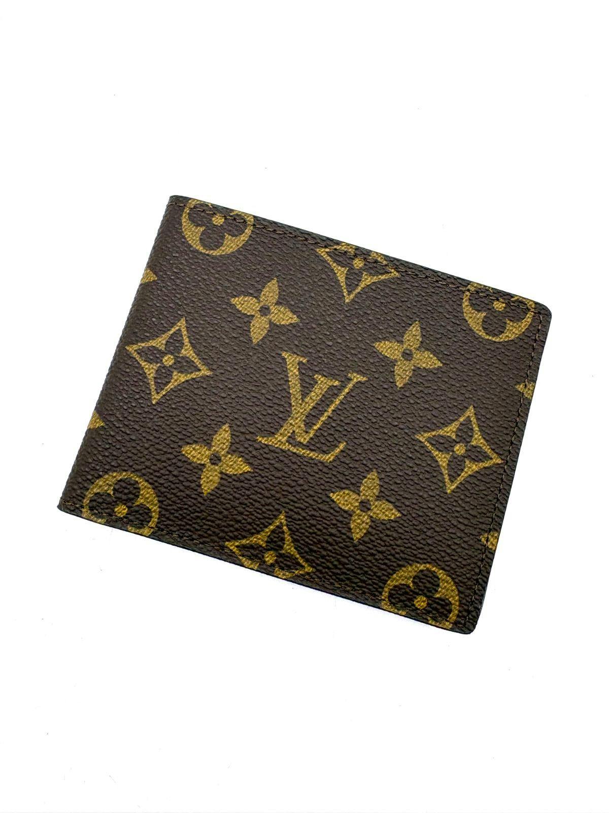 Closed Louis Vuitton monogram canvas bi-fold wallet shown on a white background.
