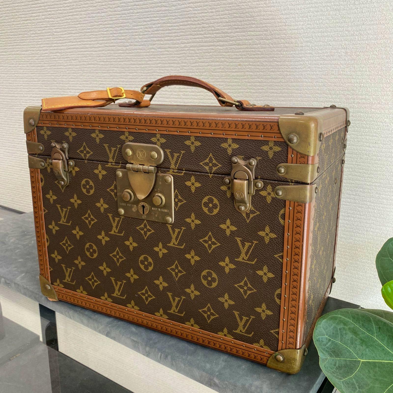 Louis Vuitton monogram cosmetic trunk case showing the top handle, front lock, brass corner hardware, and monogram canvas.