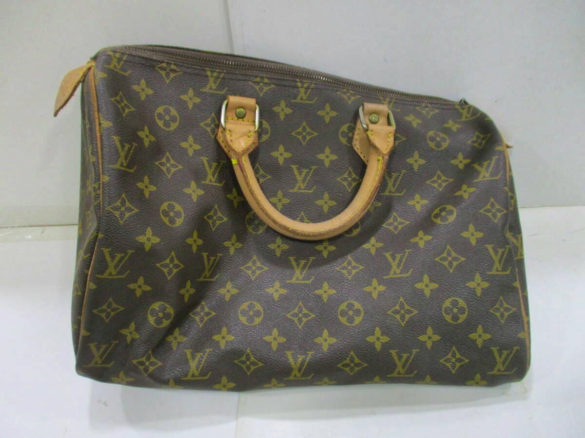 Front view of a brown Louis Vuitton monogram Boston bag with two short handles on a white surface.
