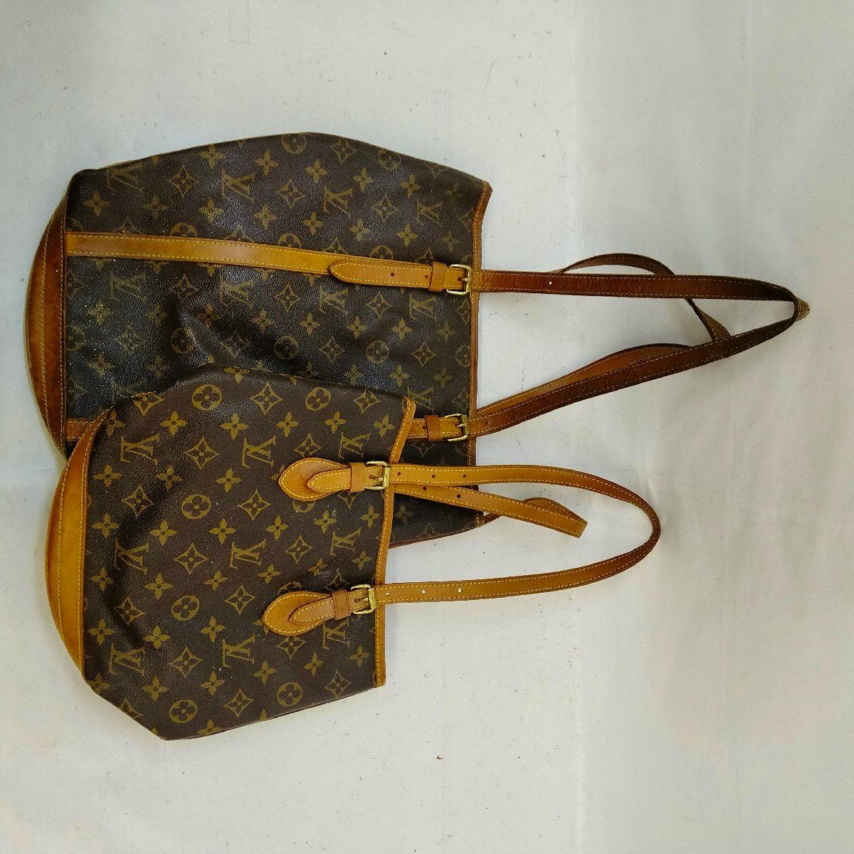 Two Louis Vuitton monogram canvas bucket bags laid flat showing the exterior pattern and leather straps.